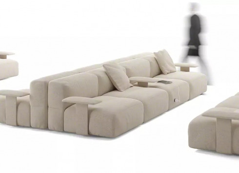 on white image of a savia sofa and a person walking next to it