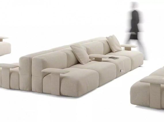 on white image of a savia sofa and a person walking next to it